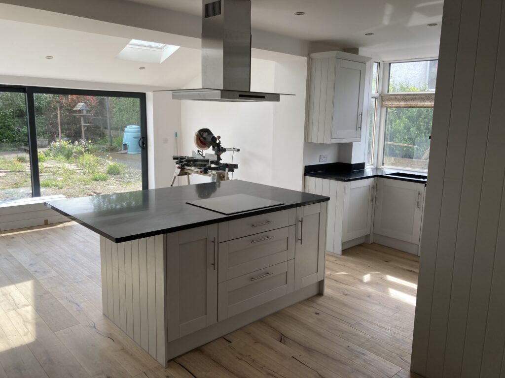 Finished Wren kitchen installation in Blackburn with central island, induction hob and stainless steel extractor